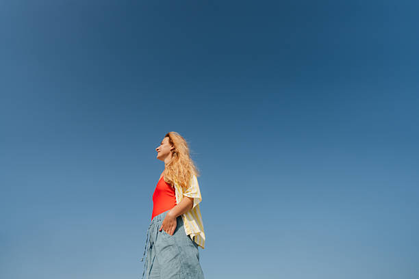 Photo of a mid adult woman enjoys sunshine and beautiful view on the local beach