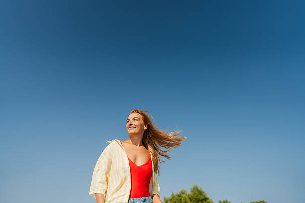 Photo of a mid adult woman enjoys sunshine and beautiful view on the local beach