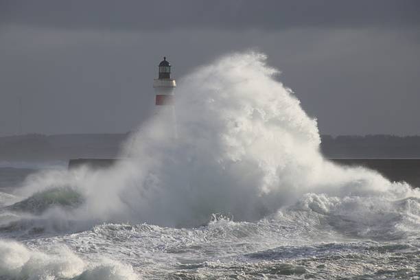Heavy seas at Peggy's Cove Lighthouse in morning sunlight.