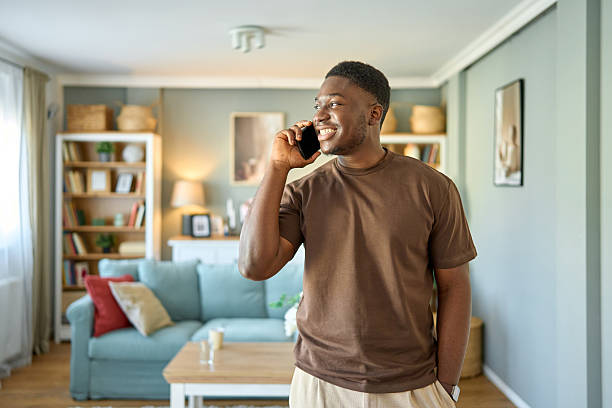 Happy black man having phone call at home