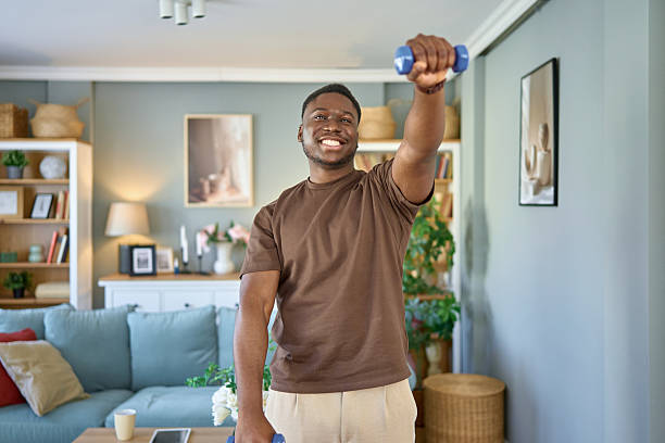 Young black man doing home workout with dumbbells