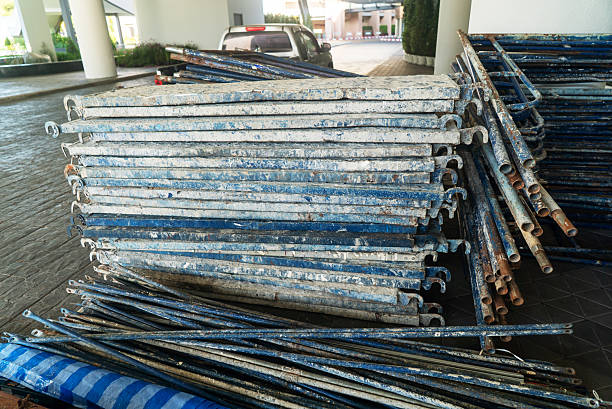A collection of weathered metal pipes stacked in a construction site, showcasing the industrial aspect of urban building projects and equipment.