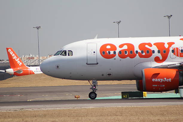 Amsterdam, Netherlands: January 04, 2015: Passengers board an EasyJet airplane at Schiphol airport. EasyJet is a British airline operating under the low-cost carrier model, based at London Luton Airport