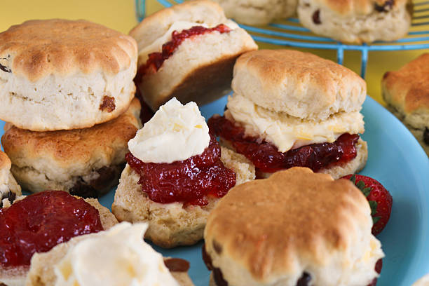 Scones, with their enticing golden color and natural cracks, appear on baking paper, creating a warm and fragrant baking atmosphere.