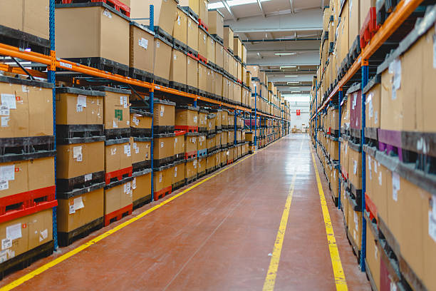 Rows of many shelves with cardboard boxes in storage room of huge distribution warehouse aisle in industrial storage factory background XXXL size