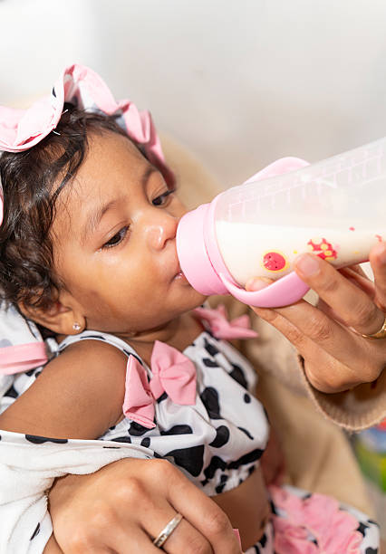 One feeding bottle with infant formula on white background