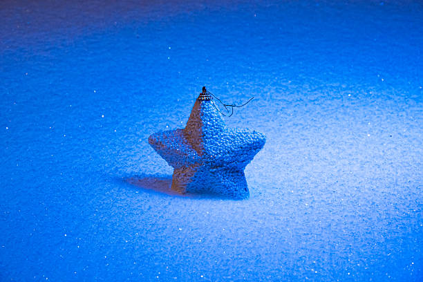 This is a detailed closeup image capturing the exquisite star decoration beautifully adorning the top of a festive Christmas tree