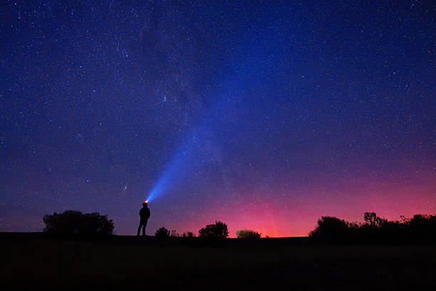 istock Silhouette of Person Using Headlamp Under Starry Night Sky With 2257471641