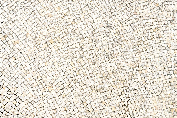 Directly above a large area of small stones, arranged on a city sidewalk.