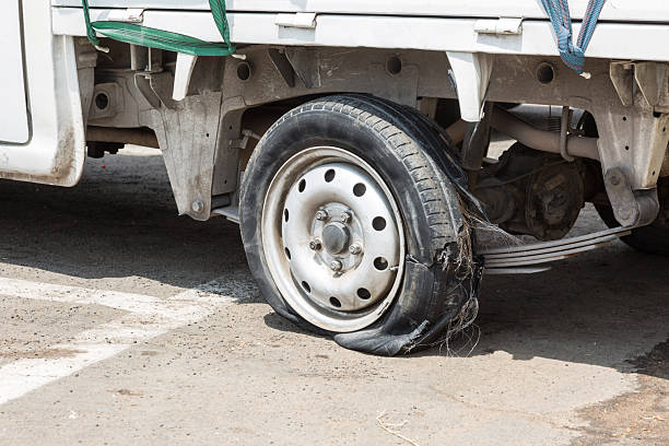 Close up of a completely unusable tire after suffering a puncture while driving on the road