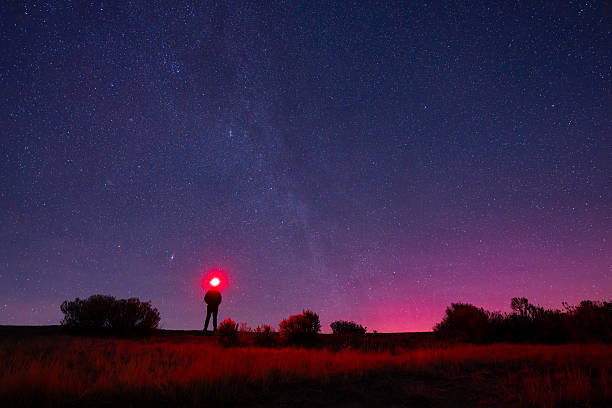 istock Man Standing Under Stars with Red Headlamp Light 2257491301