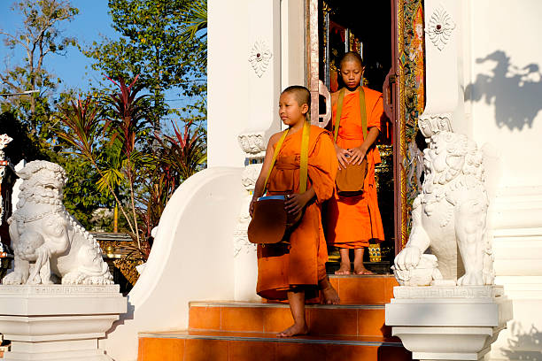 A Thai Buddhist novice wearing a robe walks for alms in the morning in Thailand.