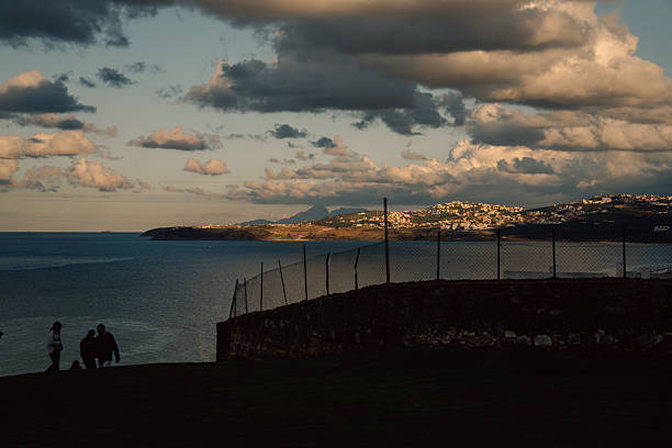 Tangier, Morocco, January 15, 2026: Locals and tourists looking at strait of gibraltar in Tangier by Jewish cemetery.The strait lies in the territorial waters of Morocco, Spain, and the British overseas territory of Gibraltar. Under the United Nations Convention on the Law of the Sea, foreign vessels and aircraft have the freedom of navigation and overflight to cross the strait of Gibraltar in case of continuous transit.The Jewish cemetery in Tangier, Morocco, contains more than 1,000 graves, some of them dating back to the 16th century.