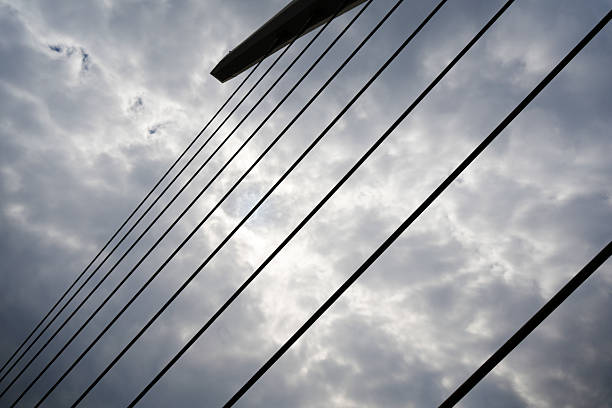 Modern Suspension Bridge Cables Framing a Dramatic Sky – Structural Lines and Nature