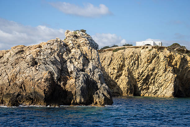 bare rocky high cliffs typical coast with cloudy sky in Ibiza, Spain