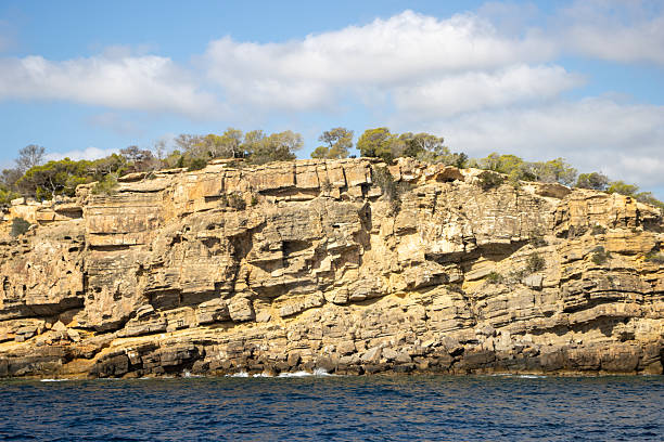 bare rocky high cliffs typical coast with cloudy sky in Ibiza, Spain