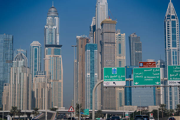 Dubai, United Arab Emirates - January 14, 2026: Dubai skyline with tall skyscrapers and road signs indicating directions, highlighting the city's urban landscape