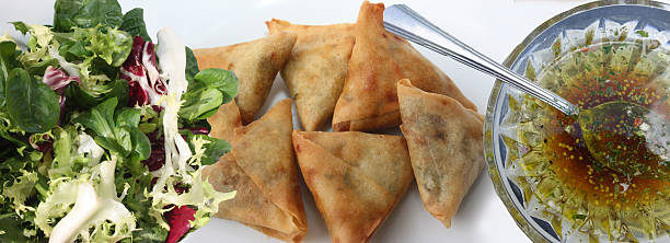 Samosa filled with spiced beef and mashed potatoes, served with a mixed green salad and vinaigrette dressing.