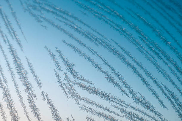 Iced windows in winter. Frost creates all kind of figures on window. Blue sky