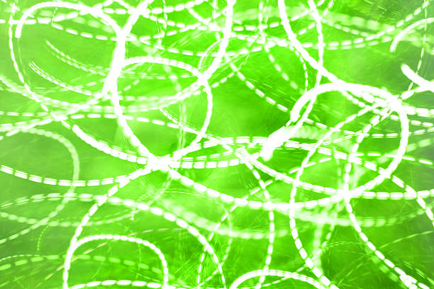 Bright green light patterns create swirling designs in a lively setting. This event takes place indoors at night, showcasing a vibrant and active atmosphere.