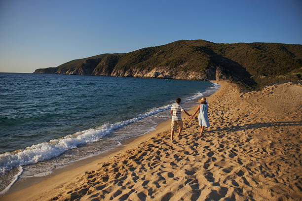 Senior couple enjoying sunrise on a beach vacation. Active seniors.