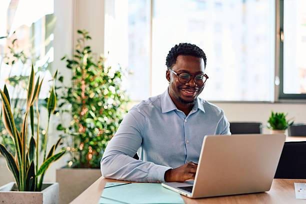 istock Black businessman smiling working laptop modern office 2257574240