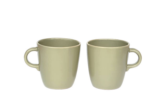 Minimal ceramic tableware set including two matte green mugs, white bowl, small plate and textured dipping bowl isolated on white background. Modern kitchenware concept for dining, home decor and life