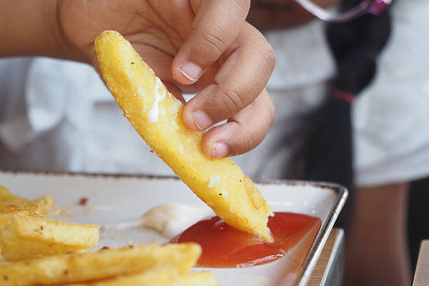 Freshly cut potatoes frying in hot oil, transforming into crispy golden fries in the hotel's kitchen, perfect for a delicious side dish