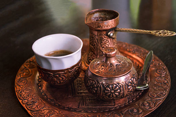 Set of traditional brass pottery designed for ritual coffee drinking, showcasing Ottoman Turkish craftsmanship. This elegant collection includes coffee pot, cups,  decorative engraved tray and serving accessories, reflecting cultural heritage, artisanal metalwork, and the timeless tradition of ceremonial coffee preparation. Ideal for editorial, lifestyle, travel, and cultural storytelling.