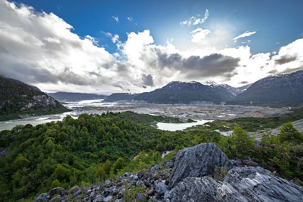 View of the rocky peaks of the Cuernos del Paine in Chile, with clear blue skies and rugged terrain, highlighting the dramatic mountain formations.