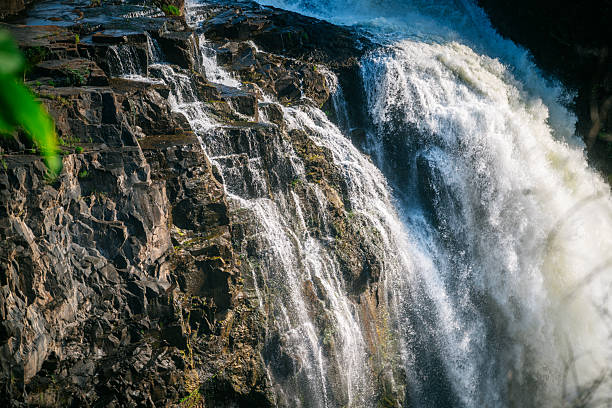 A powerful waterfall plunges over rugged rocks with mist and spray. Victoria Falls scene emphasizes natural beauty, adventure, and dramatic landscape along the Zambezi River at the Zambia-Zimbabwe border.