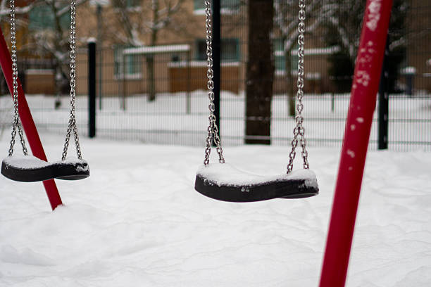 Snowy playground with empty swings in winter