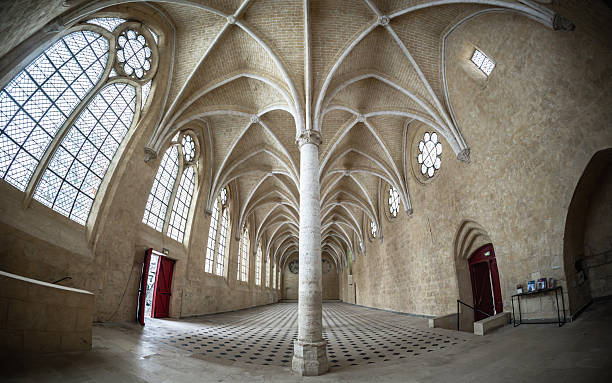 View of the interior architecture of a medieval historic building in Soissons, France. The vaulted stone ceiling and arched windows are visible inside the empty interior.