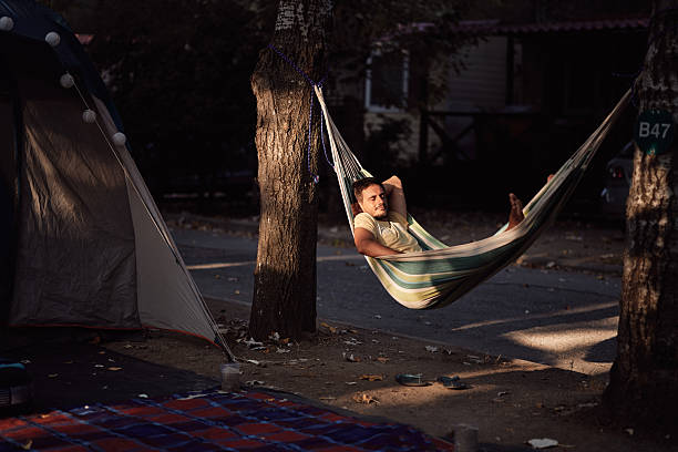 Man enjoying hammock by the tent in nature. Summer vacation.