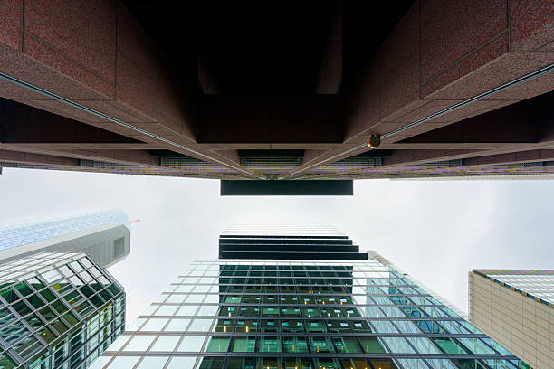 Frankfurt, Germany - October 21, 2025: Stunning low angle perspective showcases the towering skyscrapers of Frankfurt under a cloudy sky.