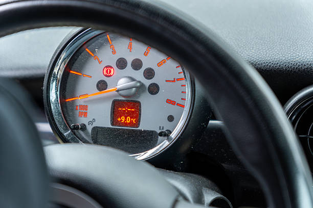 Close view of a car dashboard highlighting the temperature gauge, which shows nine degrees Celsius, as sunlight filters into the car.