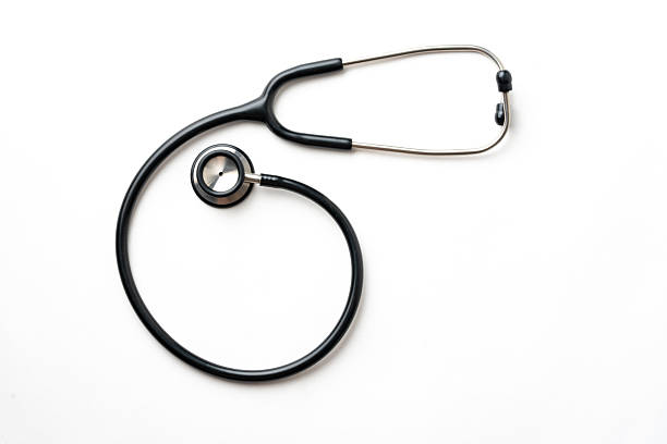 a high-angle, minimalist shot of a classic black medical stethoscope curled on a clean white surface. The image features ample negative space on the right, making it ideal for medical headlines, healthcare advertising, and insurance concepts.