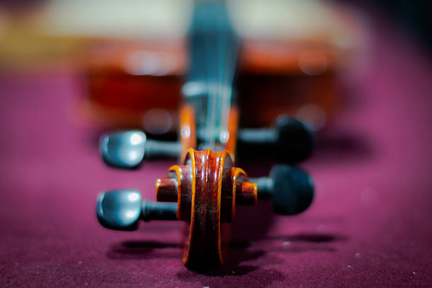 A beautiful violin and bow are set on a geometric-patterned surface. The image captures the intricate details of the violin's craftsmanship, evoking a sense of musical elegance.