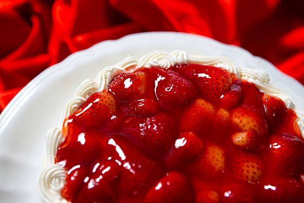 A slice of strawberry cake on a white plate. 