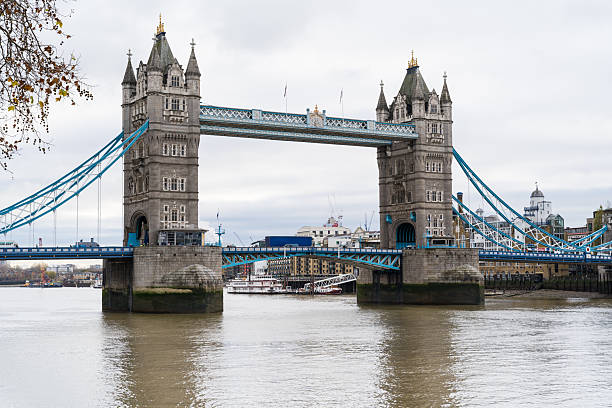 A clean, wide-angle landscape shot of the Tower Bridge over the River Thames on a bright, overcast day, showcasing the Victorian Gothic architecture.