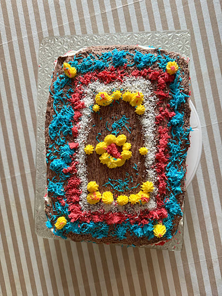 Colorful cake decorated with lunettes. Blue and yellow cake on wooden table. Top view.