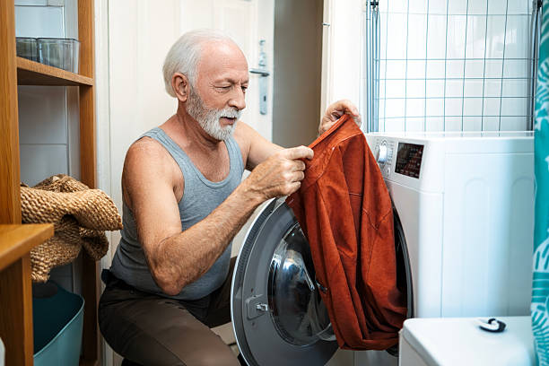 Senior man doing the laundry at home