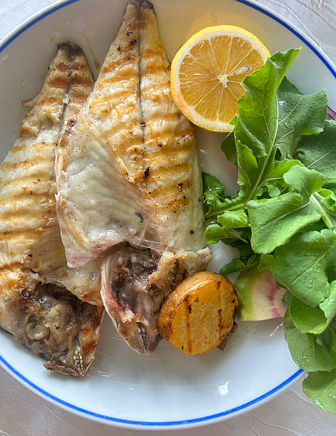 Grilled sea bream fish with lemon and salad