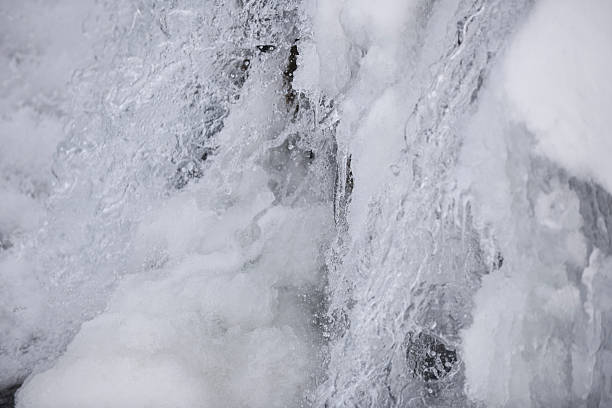 Snow, ice and spray of cold water in/near a stream of water (or a small waterfall) in Jotunheimen National Park, Norway, in early winter (October). The image was captured with a full frame DSLR camera and a sharp lens at low ISO. The photograph is part of a series of images of Jotunheimen National Park at various seasons.