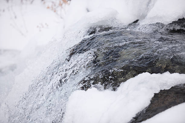 Snow, ice and spray of cold water in/near a stream of water (or a small waterfall) in Jotunheimen National Park, Norway, in early winter (October). The image was captured with a full frame DSLR camera and a sharp lens at low ISO. The photograph is part of a series of images of Jotunheimen National Park at various seasons.