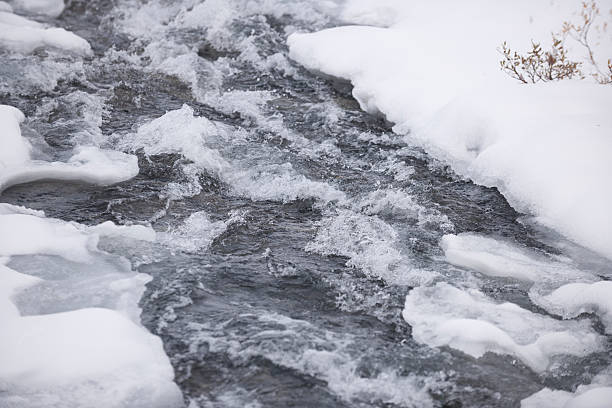 Snow, ice and spray of cold water in/near a stream of water (or a small waterfall) in Jotunheimen National Park, Norway, in early winter (October). The image was captured with a full frame DSLR camera and a sharp lens at low ISO. The photograph is part of a series of images of Jotunheimen National Park at various seasons.
