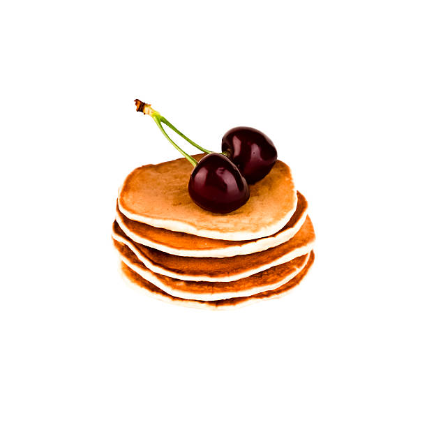 Pancakes with maple syrup, cream and black cherry on a bar table