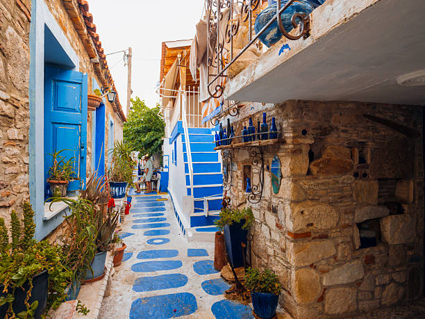 Colorful waterfront houses and traditional harbor views in Pythagoreio, a historic coastal town on Samos Island in the Aegean Sea, Greece. Clear summer skies, calm waters, and Mediterranean architecture reflect the island’s cultural heritage and relaxed seaside atmosphere.