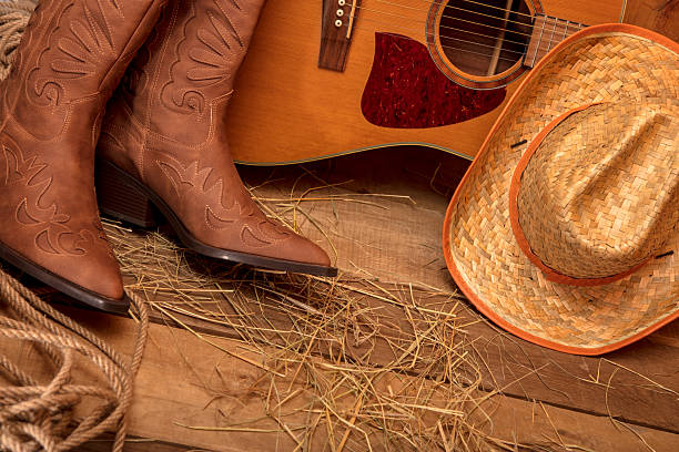 A brown cowboy hat with a black band sits on a white surface. The hat is made of straw and has a rustic, old-fashioned look