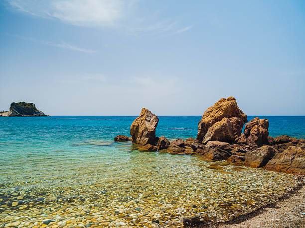 Potami Beach on Samos Island featuring clear turquoise waters, a pebble shoreline, and dramatic natural scenery along the Aegean Sea, offering a tranquil coastal atmosphere and a popular destination for summer travel in Greece.